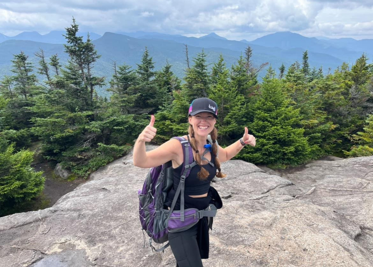Jodie Bonville giving a thumbs-up at the summit of an Adirondack High Peak